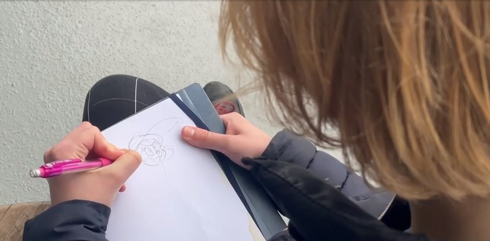 a person sitting outside sketching an image. a vancouver art student claims she was scammed out of hundreds of dollars