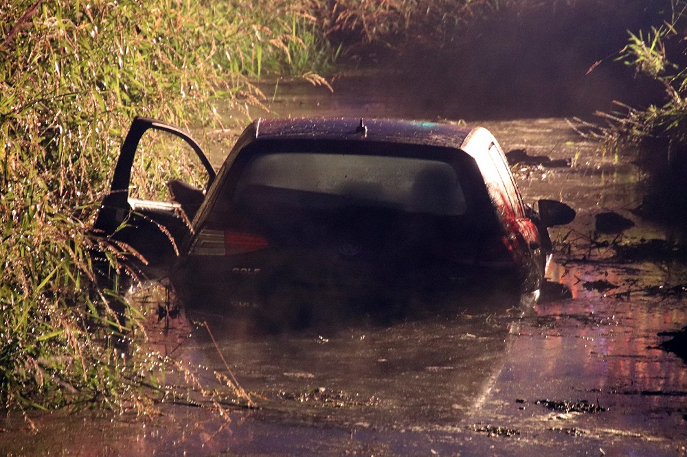 a vehicle seen in the ditch with water surrounding it at the scene of a serious crash in surrey sunday afternoon