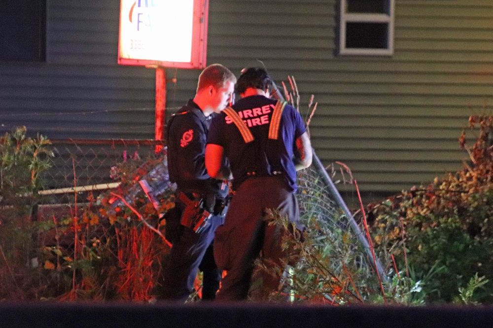 an rcmp officer and fire fighter talking outside at the scene of a crash