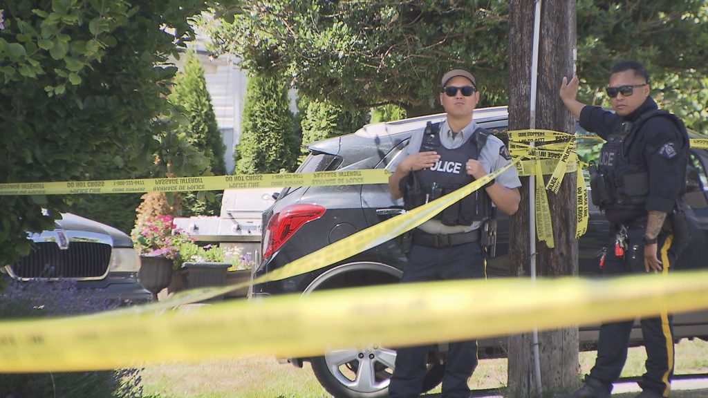 Police officer stands behind police tape