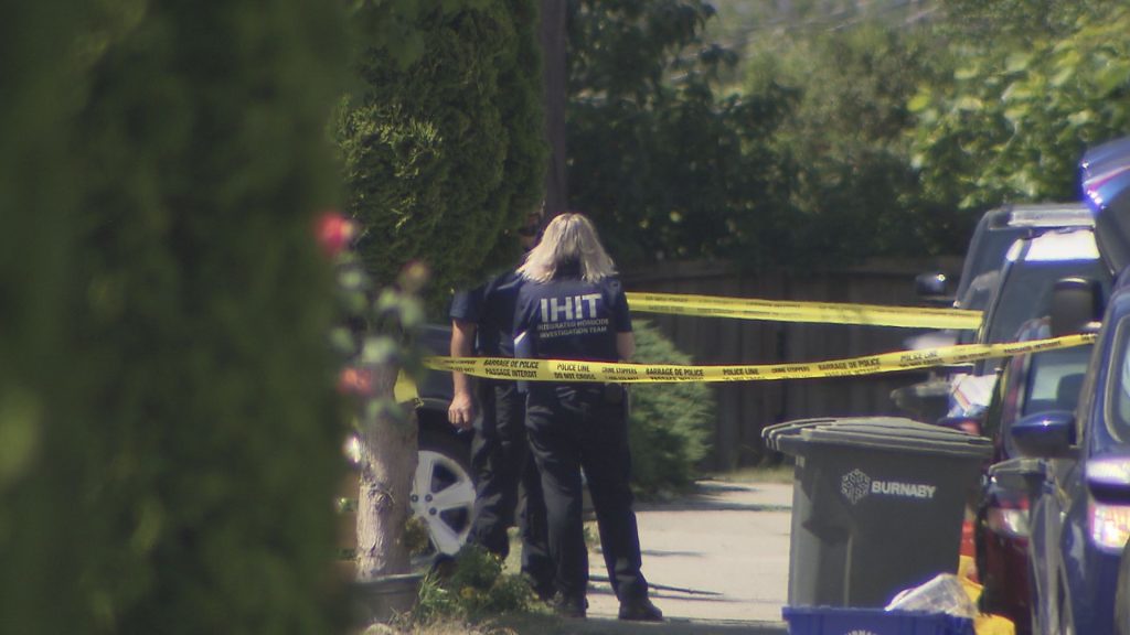 IHIT officer stands behind police tape