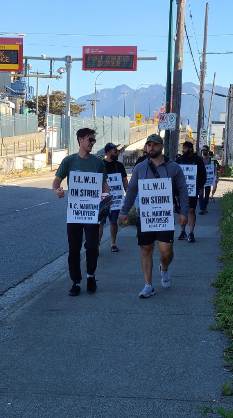 thousands of port workers are on strike. workers walk outside picketing with signs