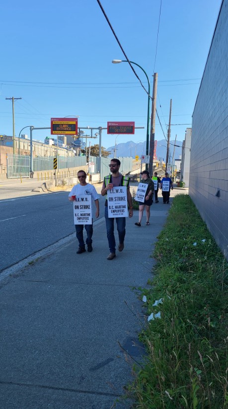 thousands of port workers are on strike. workers walk outside picketing with signs