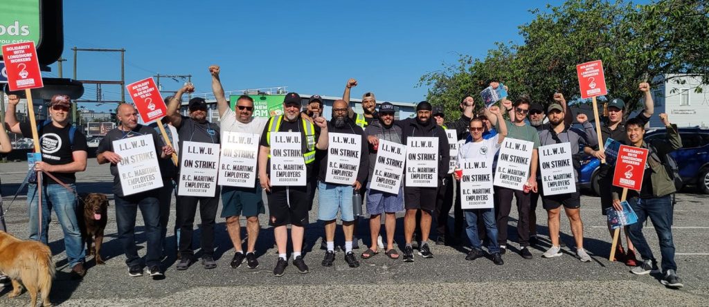 thousands of port workers are on strike. workers walk outside picketing with signs