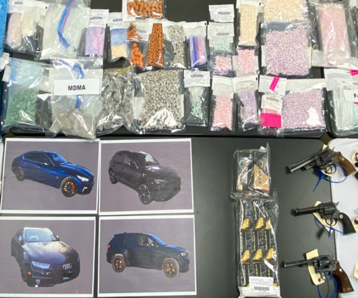 kilograms of drugs along with some hand guns are laid out on a table. they were seized in drug trafficking operation, according to the coquitlam rcmp