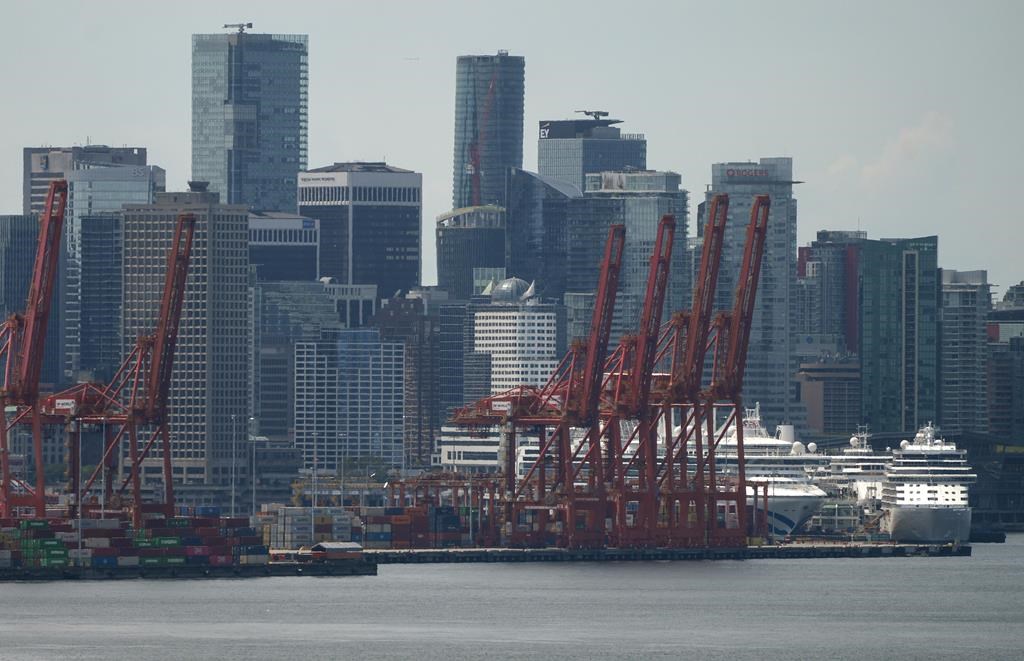 Gantry cranes sit idle above cruise ships and stacks of cargo containers at port during a strike by International Longshore and Warehouse Union Canada workers in the province in Vancouver on Wednesday, July 12, 2023