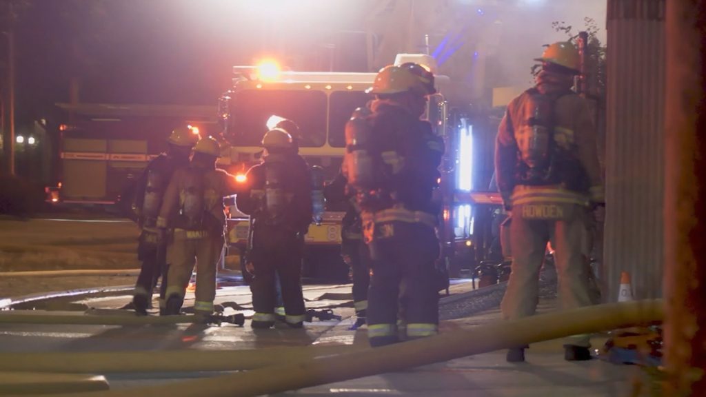 Fire crews work to put out a fire at an abandoned warehouse