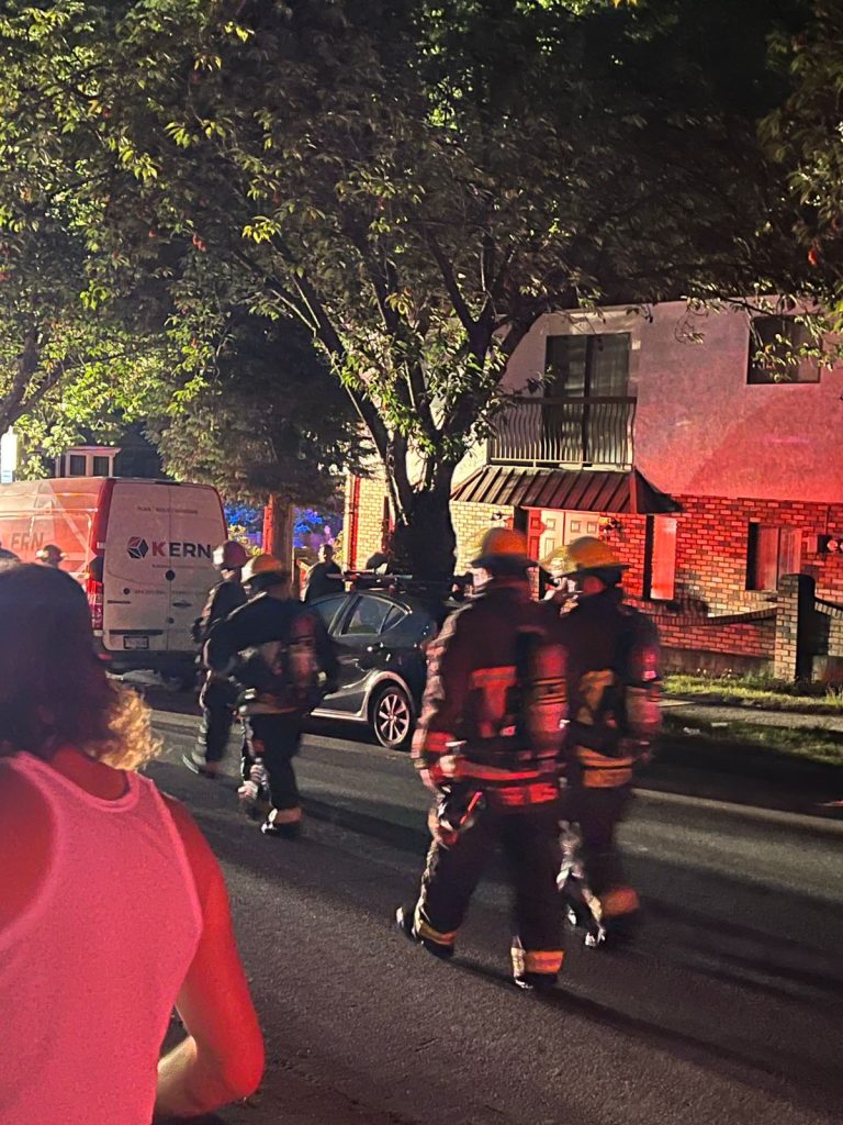 firefighters stand outside after an apartment fire ripped through a building thursday night