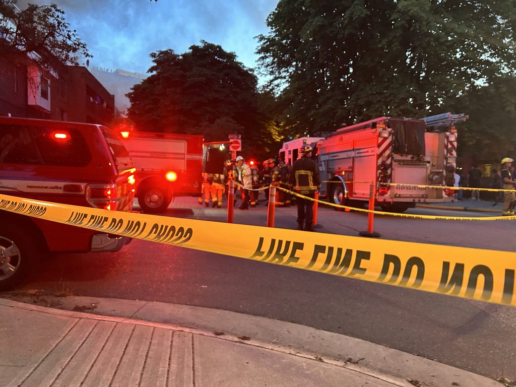 Fire crews are seen behind a fire line yellow tape