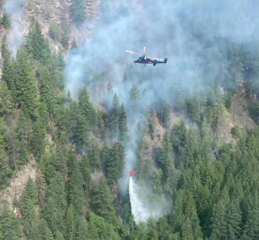 A helicopter provides air support over the Adams Lake fire.