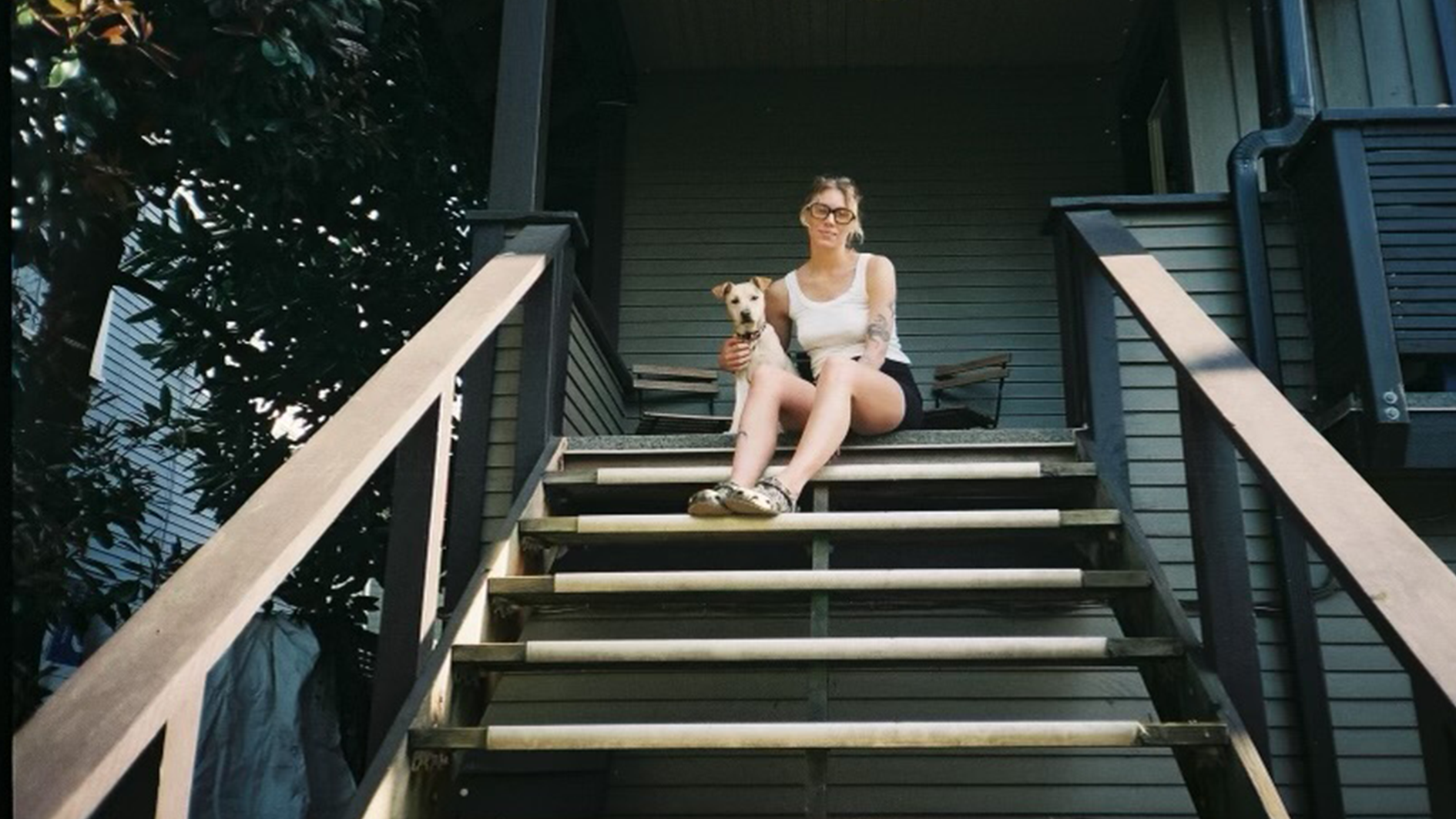 Vancouver-renter-Bryanna-Johnson Bryanna Johnson sitting on the steps of her home alongside a dog.