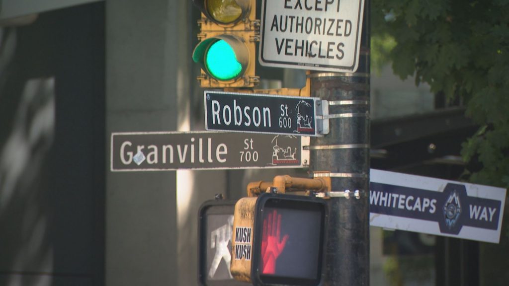 Intersection of Robson Street and Granville Street signs are seen