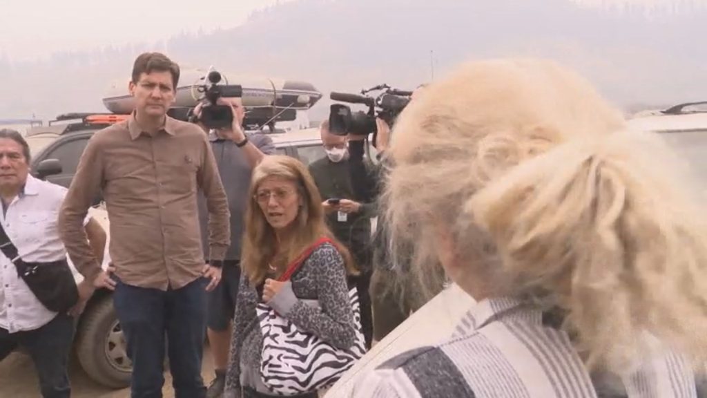 B.C. Premier David Eby stands in Kamloops during a wildfire survey where he is confronted by a local who is asking him why some people are being arrested when they are trying to help