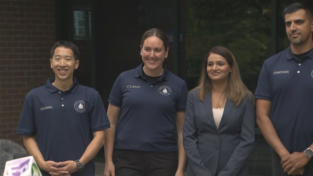 A VPD School Liaison Officer is seen in uniform with other officials