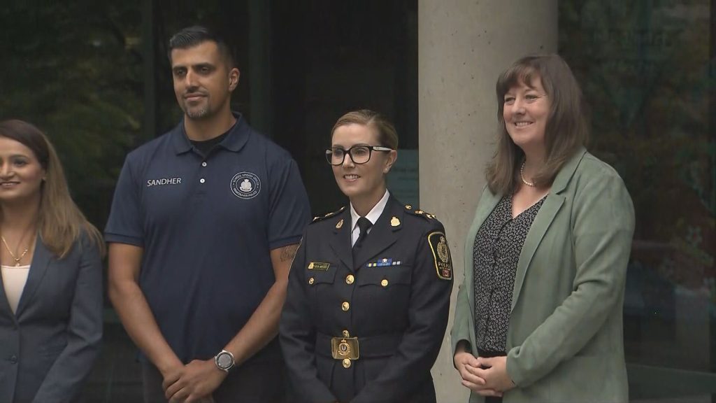 A VPD School Liaison Officer is seen in uniform with other officials