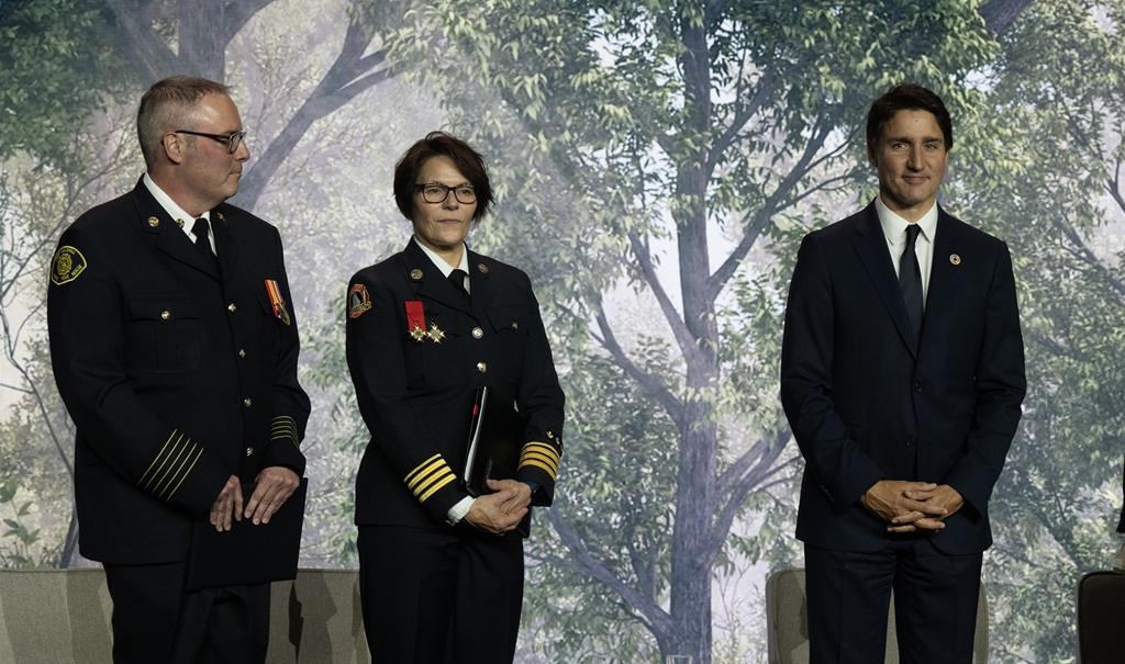 West Kelowna Fire Chief Jason Brolund, Halifax Regional Fire and Emergency Assistant Chief Sherry Dean and Prime Minister Justin Trudeau stand on stage during the the Global Carbon Pricing Challenge event at the United Nations