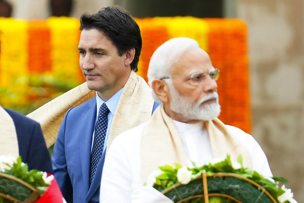 Canada's Prime Minister Justin Trudeau, left, walks past Indian Prime Minister Narendra Modi as they take part in a wreath-laying ceremony at Raj Ghat, Mahatma Gandhi's cremation site