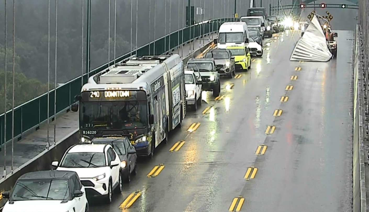 Crews drag a large piece of metal off the deck of the Lions Gate Bridge.