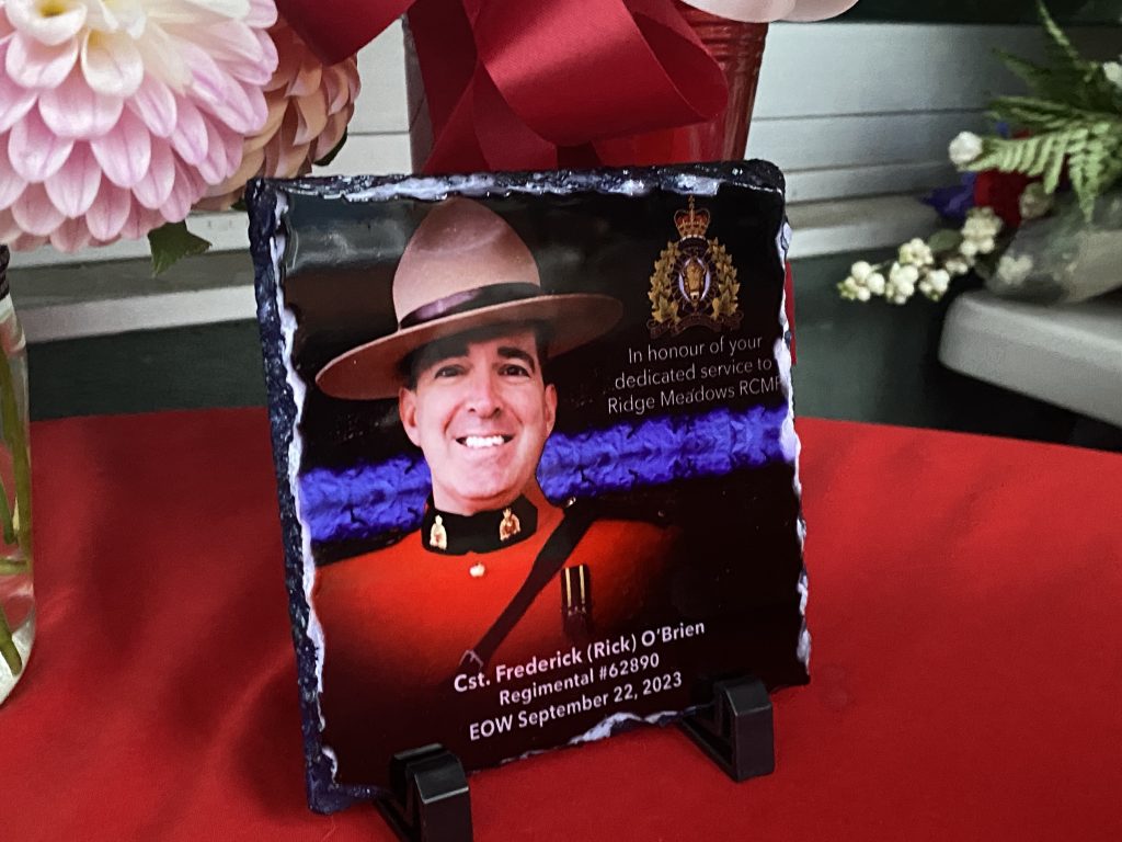 Messages of love surround a photo of Const. Frederick O'Brien on a table draped in RCMP red and insignia. (Mike Lloyd / CityNews)