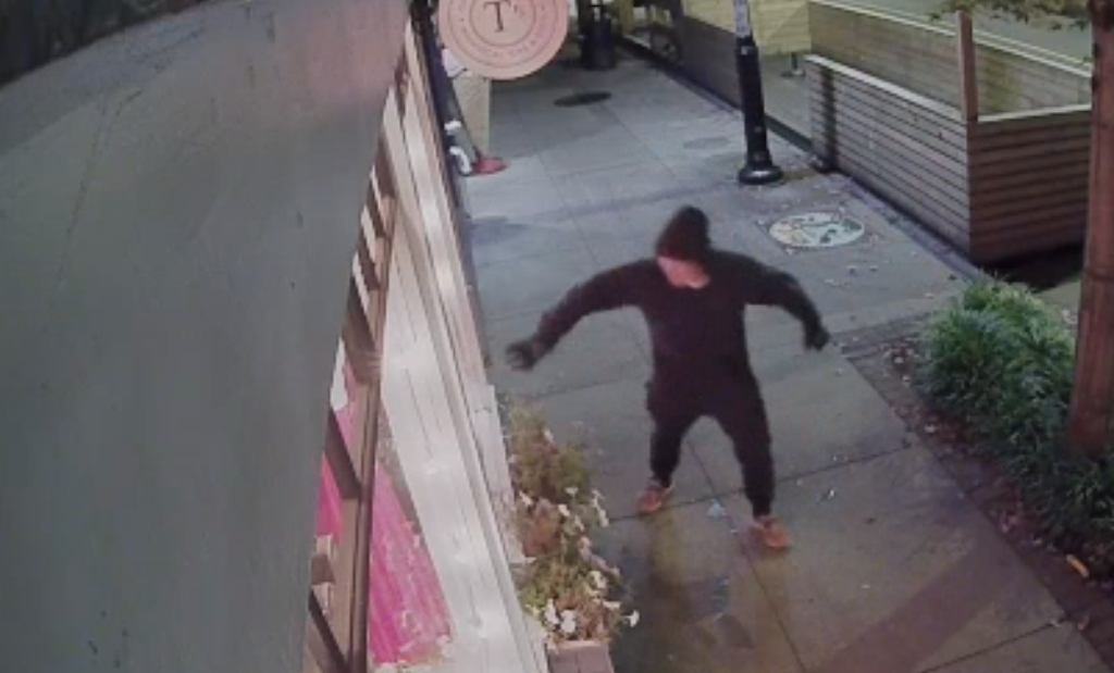 A person is seen throwing something into the Once Upon A Tea Leaf shop in Maple Ridge on Thursday, Sept. 21, 2023, after the business' front windows were smashed.