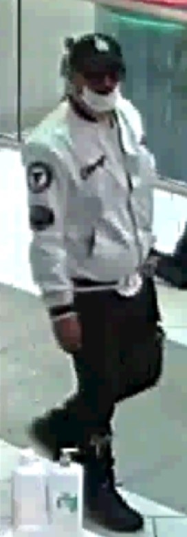 One of two suspects wanted in connection with a reported theft and assault at Metrotown Mall in Burnaby on Sept. 17. This person is wearing a dark-coloured baseball cap with a white LA Dodgers logo on the front, a white medical mask, glasses, a white bomber jacket with the Chicago Bulls crest on it, black pants, and dark blue and purple shoes