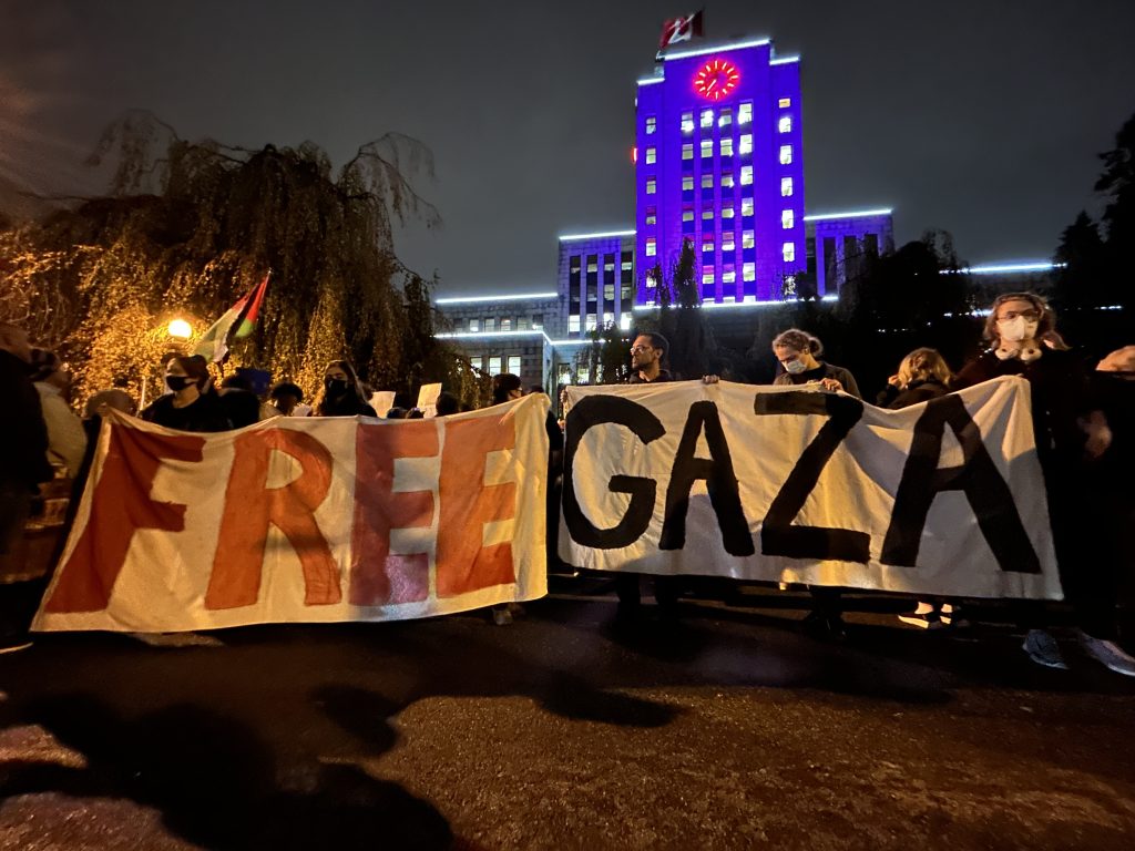 People hold up a 'Free Gaza' sign outside Vancouver City Hall