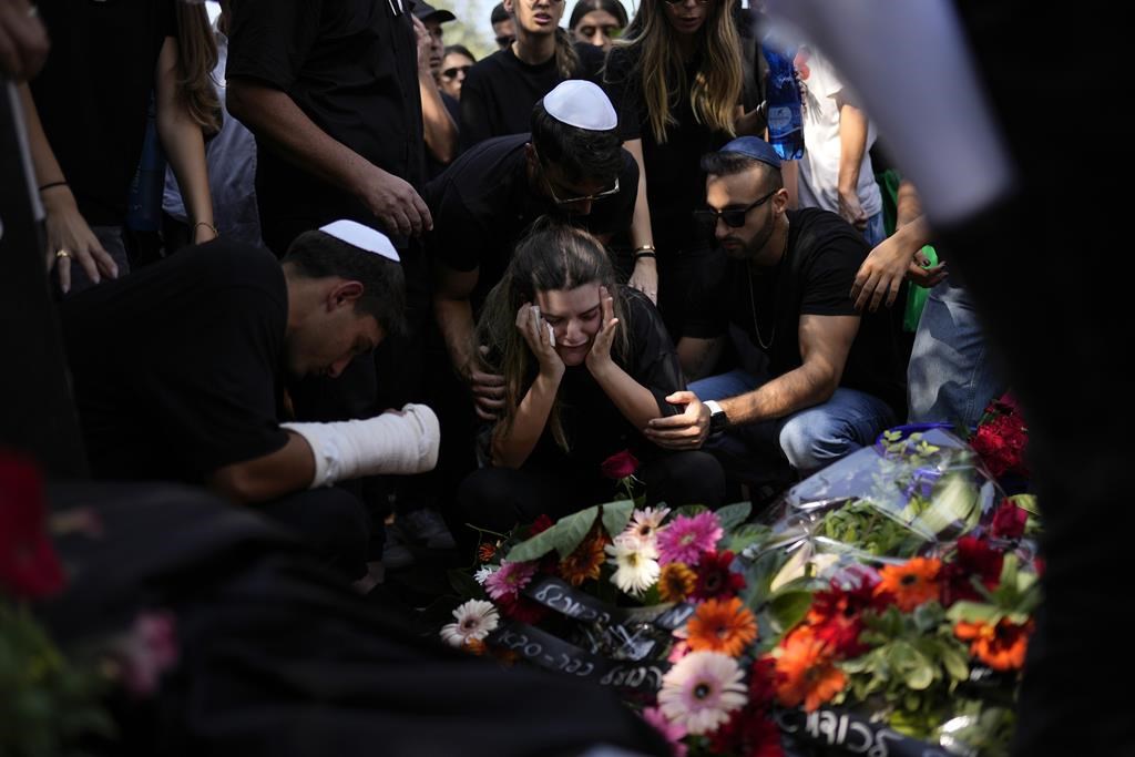 Mourners gather around the grave of May Naim, 24, during her funeral in Gan Haim, central Israel, Wednesday, Oct. 11, 2023. Naim and at least 260 more Israelis were killed by Hamas militants on Saturday at a rave near Kibbutz Re'im, close to the Gaza Strip's separation fence with Israel as the militant Hamas rulers of the territory carried out an unprecedented, multi-front attack that killed over 1,000 Israelis.