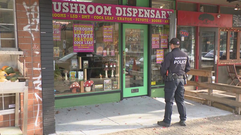 A Vancouver Police officer stands outside of a mushroom dispensary, operated by Dana Larsen, after it was raided in November 2023.
