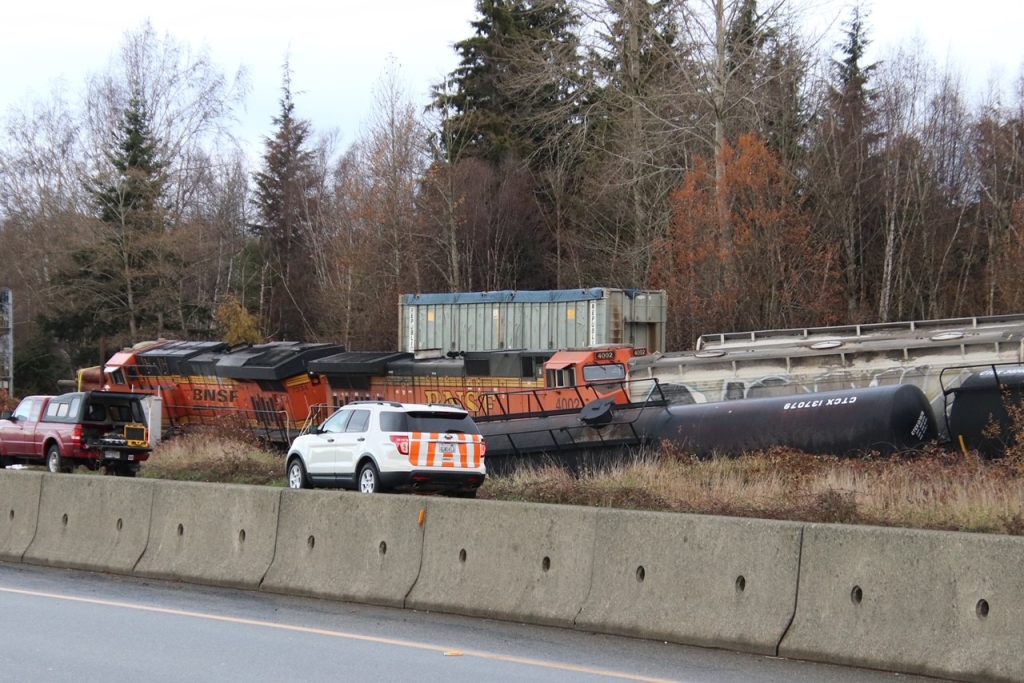 Several rail cars and machinery can be seen derailed in North Delta