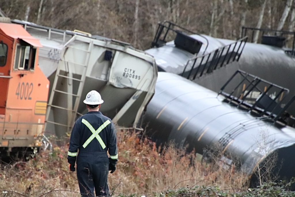 Several rail cars and machinery can be seen derailed in North Delta