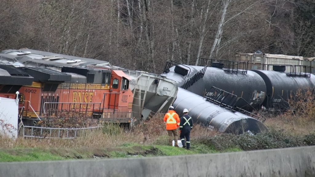 Several rail cars and machinery can be seen derailed in North Delta