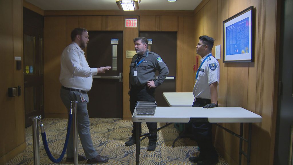 Security screens an individual at Vancouver City Hall