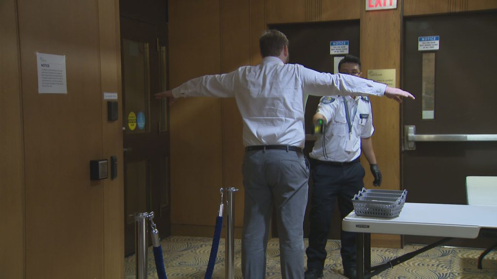 Security screens an individual at Vancouver City Hall