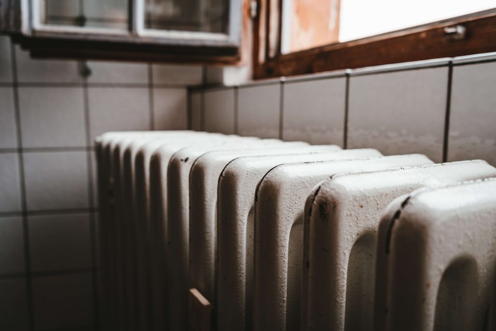 white radiator heater beside brown wooden window