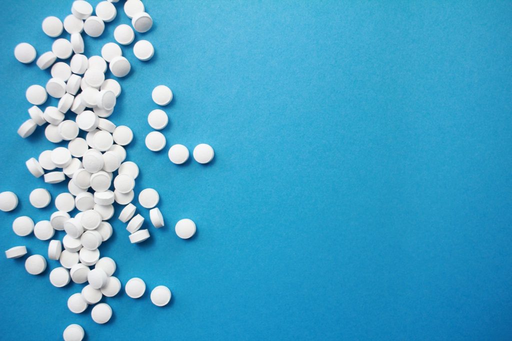 A bunch of pills laid out on a blue background