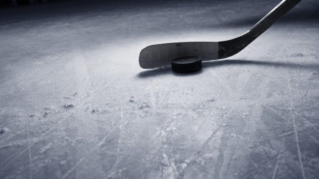 A hockey stick on the ice behind a pick