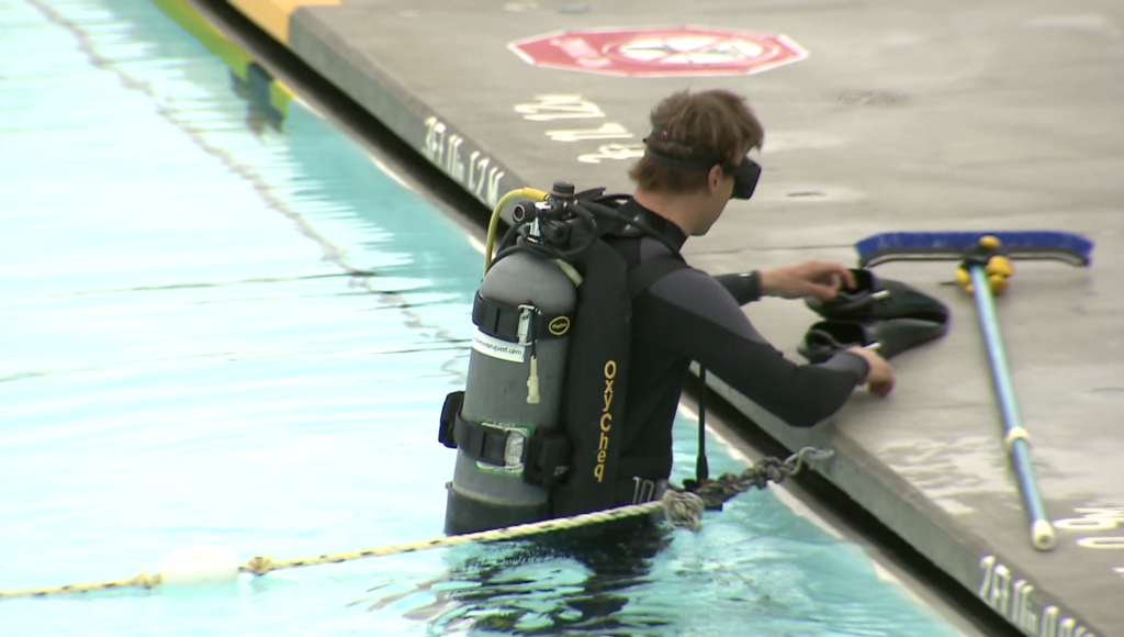 A scuba diver inspects Kitsilano Pool.