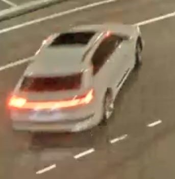 A screenshot of a video showing a white car. The vehicle is "of interest" to the Surrey RCMP in an ongoing extortion investigation