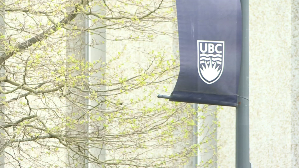 A flag on a pole with the UBC logo on it at the university's Vancouver campus