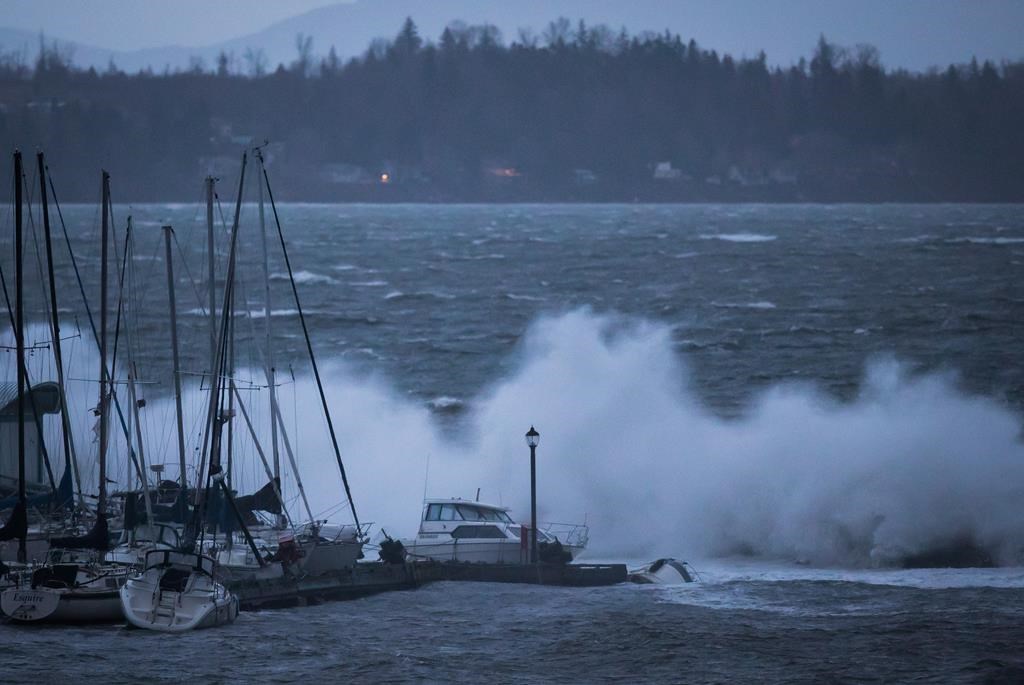 Boats are battered by waves at the end of the White Rock Pier that was severely damaged during a windstorm, in White Rock, B.C., on Thursday December 20, 2018