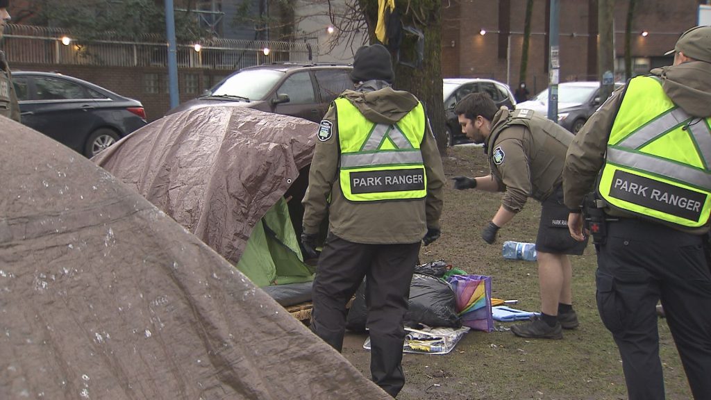 City of Vancouver Park Rangers and Vancouver Police officers dismantle tents at Oppenheimer Park in Vancouver