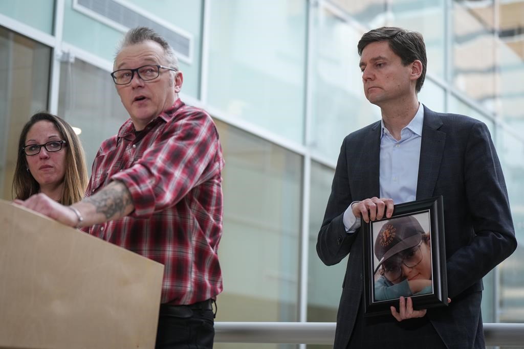 B.C. Premier David Eby says the sharing of fake intimate images of pop star Taylor Swift proves nobody is immune from such "attacks," as the province launches new services to get images taken down and go after perpetrators for damages. Eby, right, holds a photograph of late 12-year-old Carson Cleland, who killed himself last year after becoming a victim of online sextortion, as his parents Ryan Cleland and Nicola Smith speak about him during a news conference in Surrey, B.C., Friday, Jan. 26, 2024.