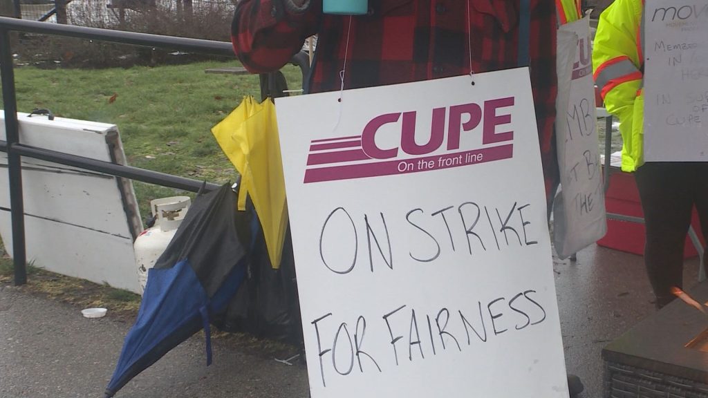 A CUPE 4500 member holds up a sign at a picket line after a 48-hour strike, halting bus and SeaBus services, began the morning of Monday, Jan. 22, 2024. 