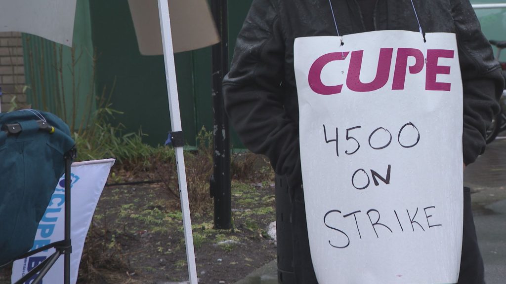 A CUPE 4500 member holds up a sign at a picket line after a 48-hour strike, halting bus and SeaBus services, began the morning of Monday, Jan. 22, 2024.