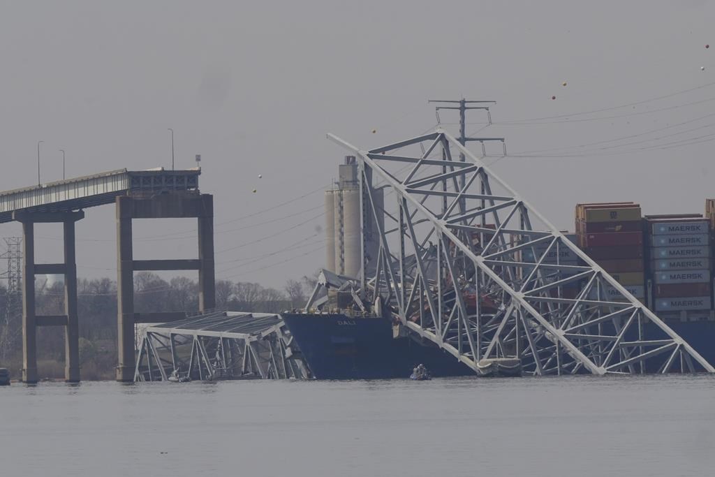 A container ship rests against wreckage of the Francis Scott Key Bridge on Tuesday, March 26, 2024, as seen from Sparrows Point, Md. The ship rammed into the major bridge in Baltimore early Tuesday, causing it to collapse in a matter of seconds and creating a terrifying scene as several vehicles plunged into the chilly river below.