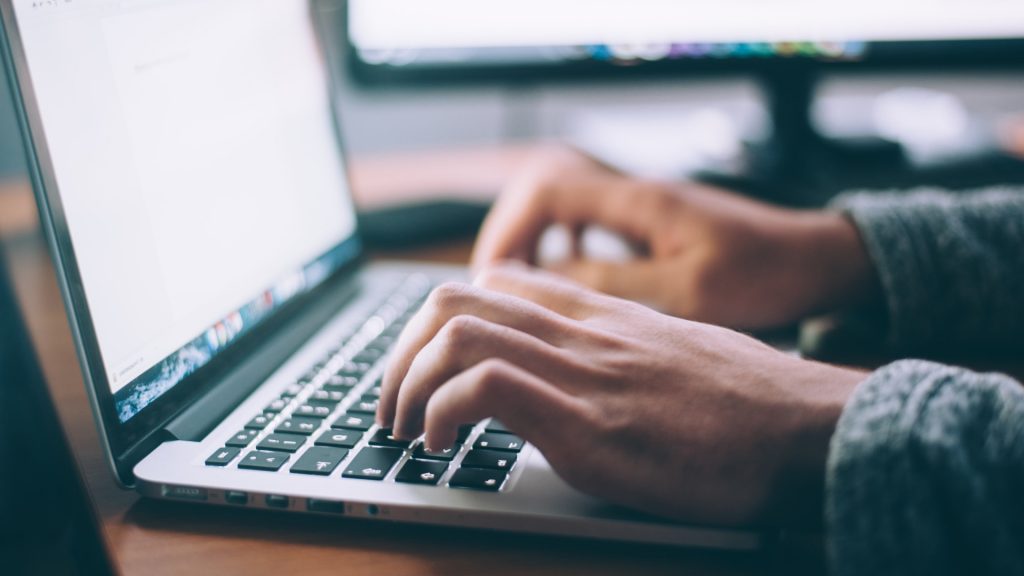 A woman is seen working on her computer.