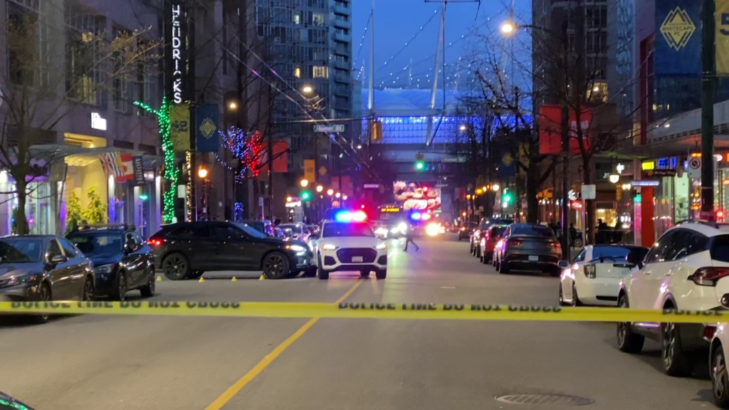 A black SUV that crashed into a white SUV is seen with multiple evidence markers surrounding it Downtown Vancouver near Robson and Richards