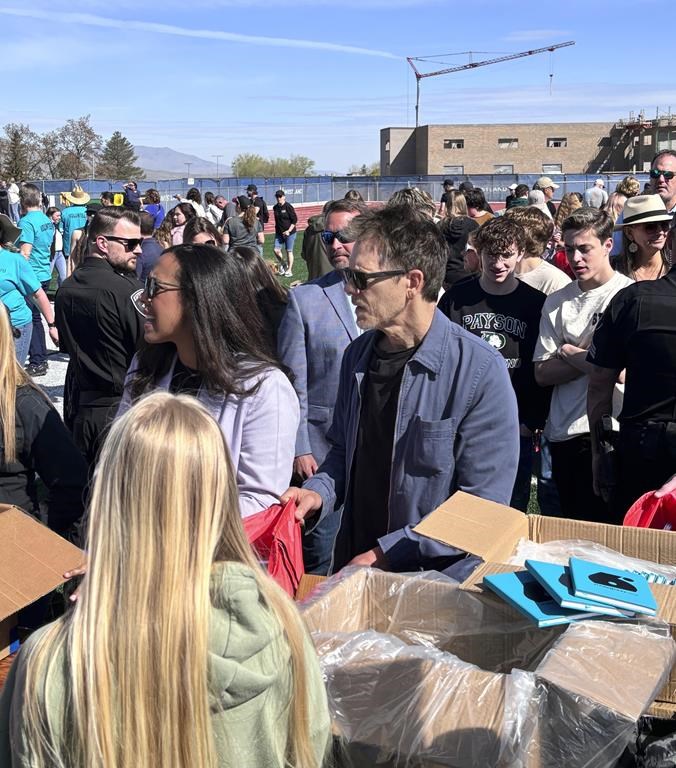 In this photo provided by Jesse Sorenson, actor Kevin Bacon, center, helps fill care packages for his charity, Saturday, April 20, 2024, in Payson, Utah, while visiting the Utah high school where cult classic "Footloose," was filmed.