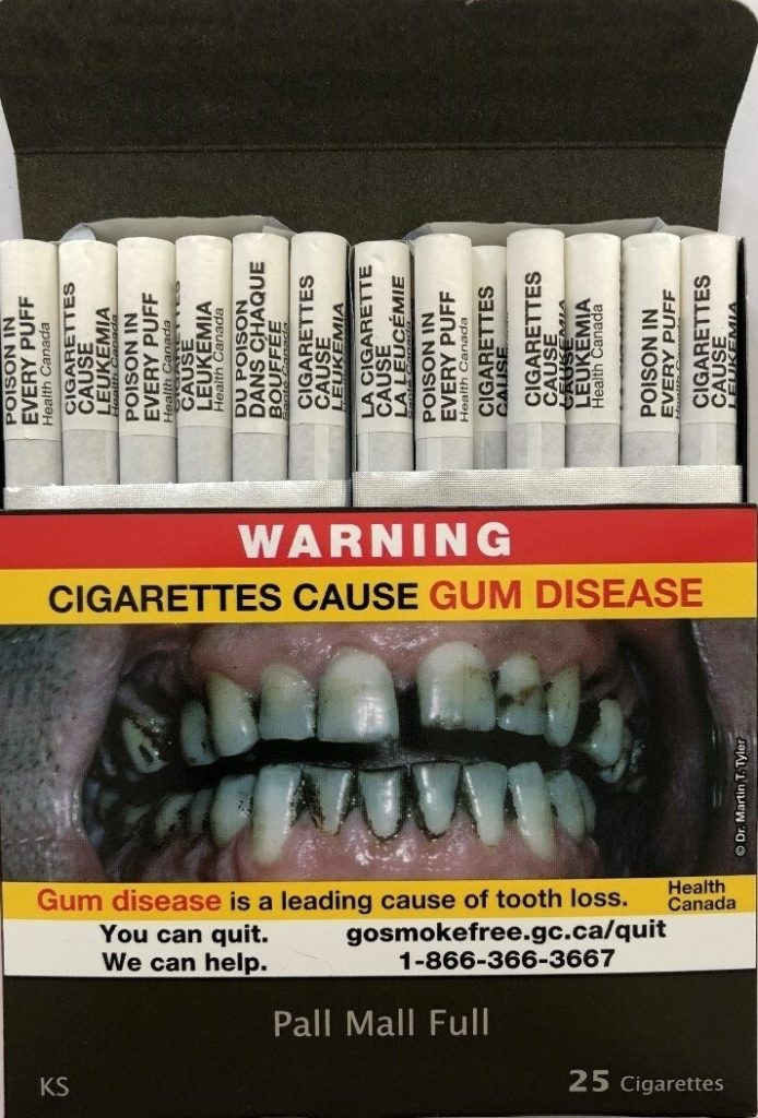 A photo shows warnings printed on individual cigarettes in a pack featuring updated images in Canada.