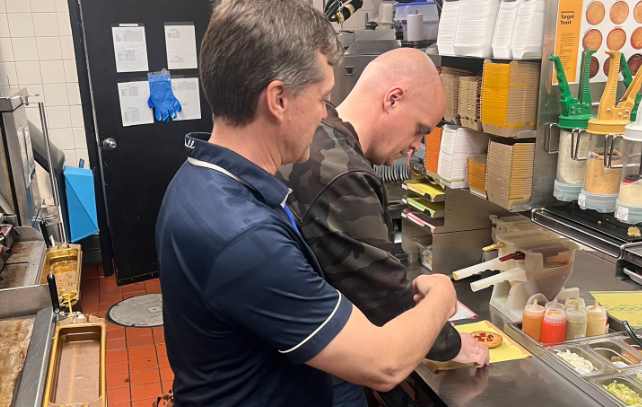 CityNews Meteorologist Michael Kuss and Afternoon Drive Anchor John Ackermann assemble burgers at a McDonald's in Vancouver for McHappy Day 2024.